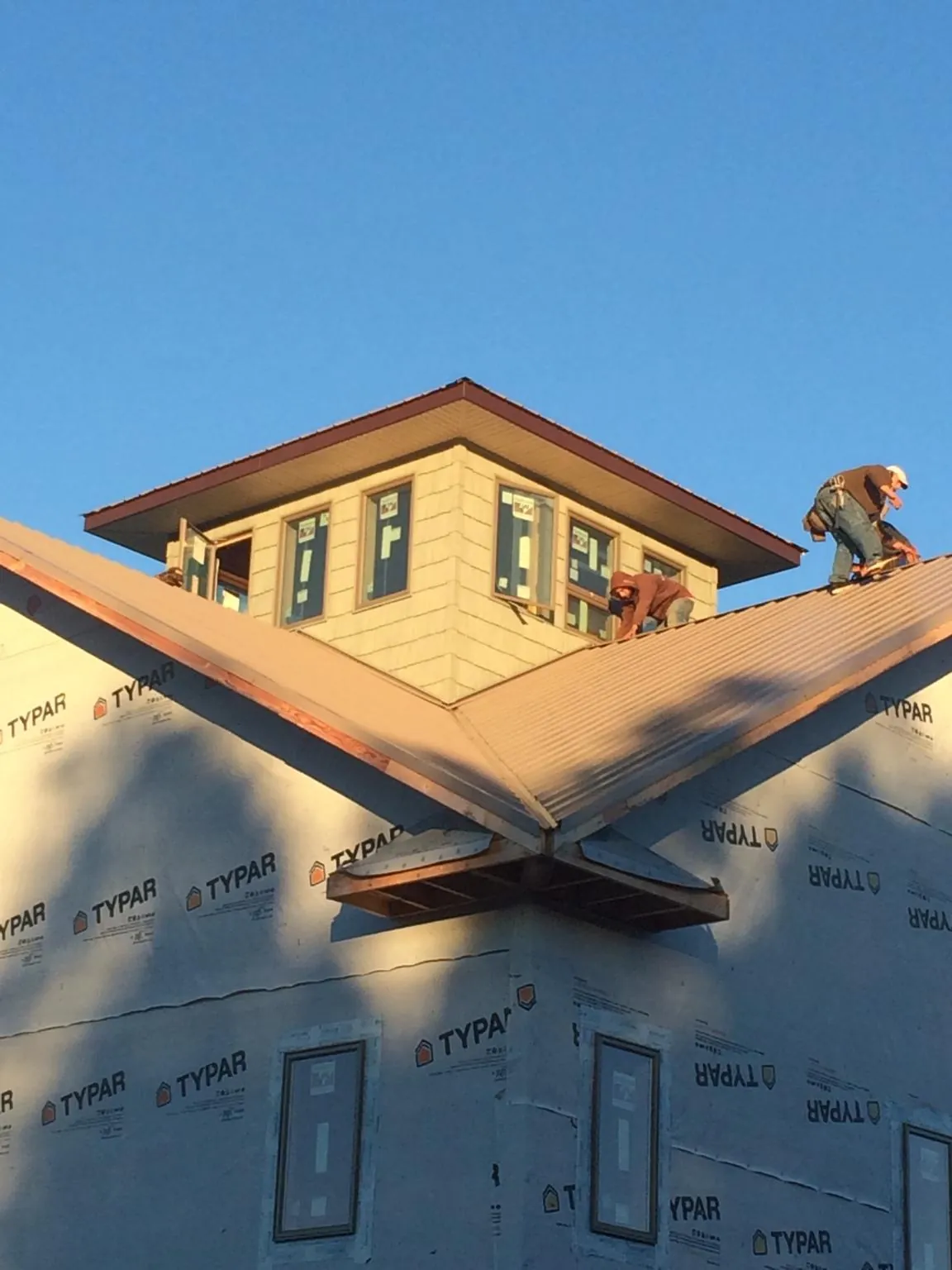 Roofers working around a rooftop cupola on a new metal roof at sunset — Roof Waterproofing in Damascus by Roofing Brothers
